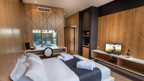 Ein modernes Hotelzimmer mit einem großen Bett, einem Schreibtisch mit Stuhl, einem Fernseher und einem großen Spiegel.