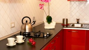 A kitchen with a kettle, cups, and a potted orchid. - Coppelle (Rome)