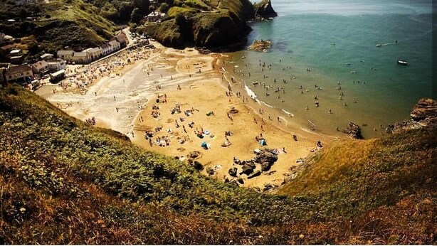 A coastal beach with a clear view of the sea and a small building on the hillside. - Rock Mill (Llandysul)