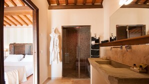 A modern bathroom with a large stone sink, a glass shower enclosure, and a mirror above the sink. - Borgo tra gli Olivi (Castiglion Fiorentino)