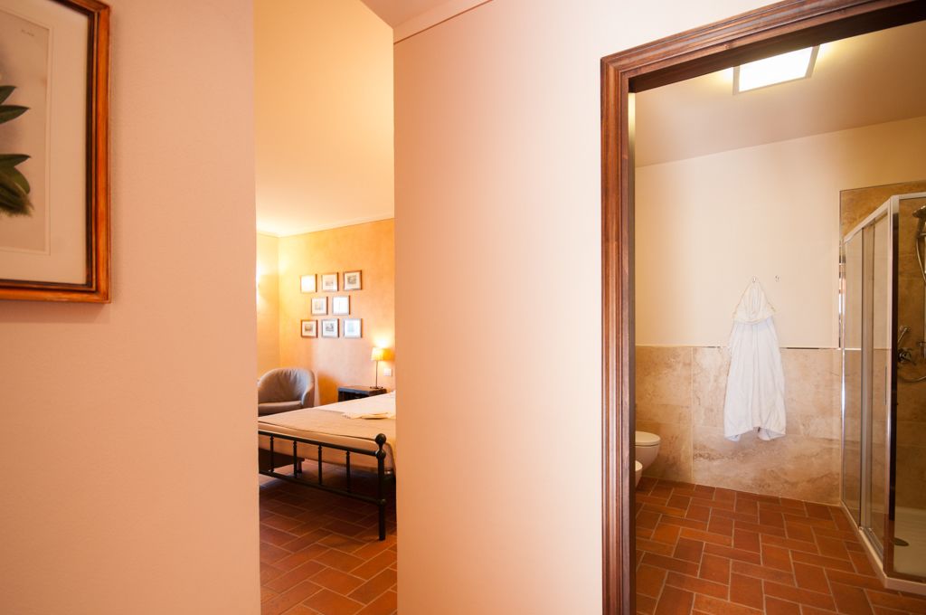 Une chambre d’hôtel comprenant un lit, une chaise, une table et une salle de bain avec douche.