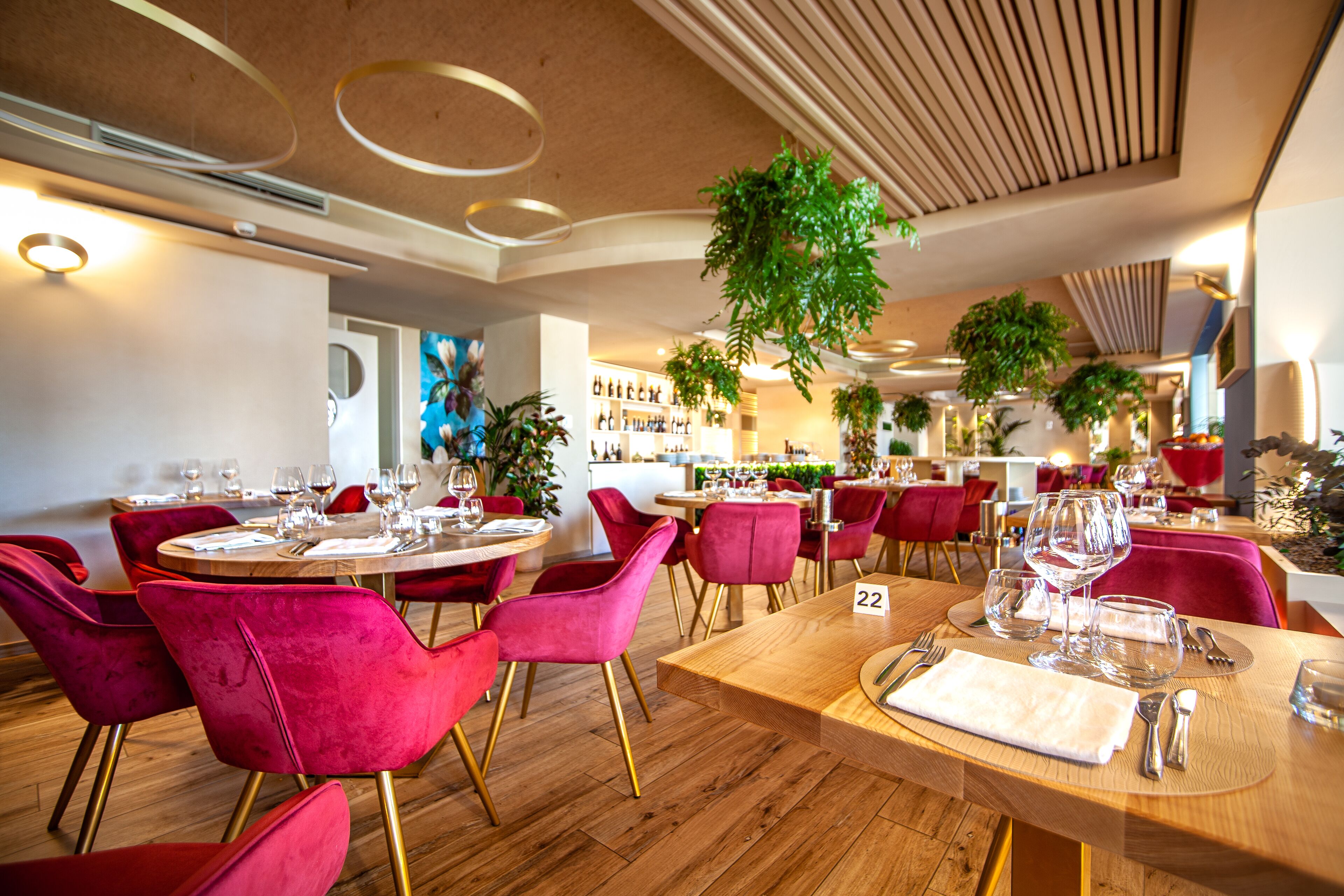 A restaurant interior with round tables, red chairs, and a number 22 sign.