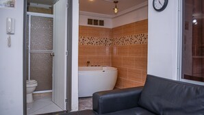 A bathroom with a bathtub, toilet, and a shower. - Park Lleras 301 (Medellín)