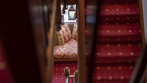 A staircase with red carpeted steps and a cushioned bench with patterned cushions. - Lyndale Guest House (Ambleside)