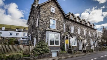 A stone building with a traditional design, featuring multiple windows and a prominent entrance.
