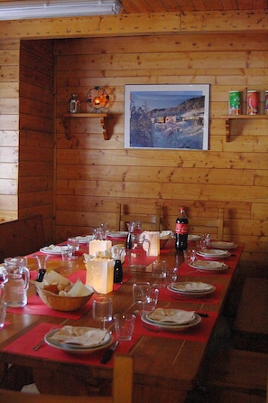 A wooden interior with a long dining table set for a meal. - Camping Yoghi e Bubu (Roburent)