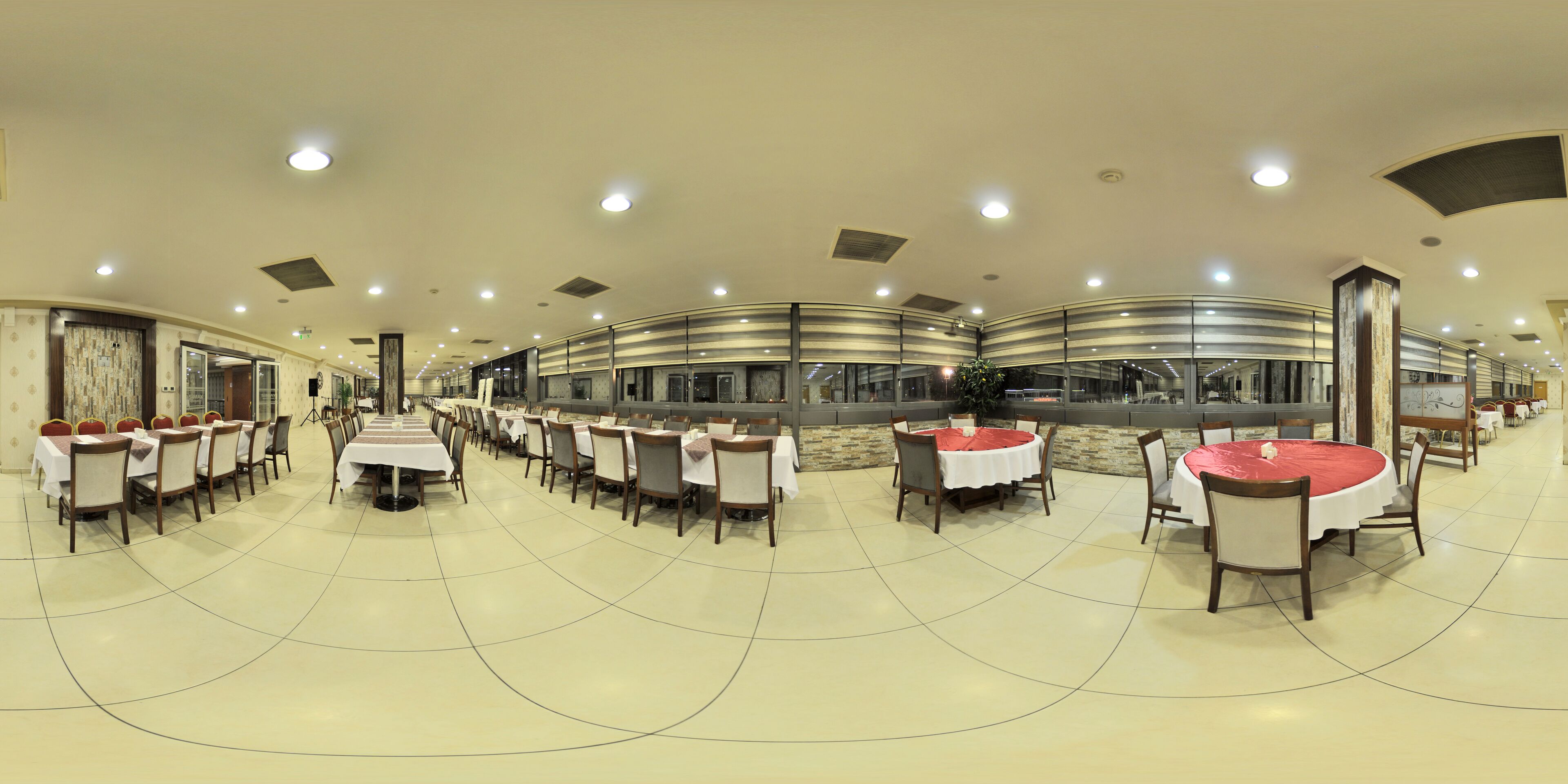 A spacious dining area with multiple tables and chairs, arranged in a curved layout.