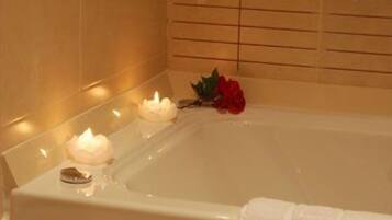 Eine Badewanne mit Kerzen und einer Rose.