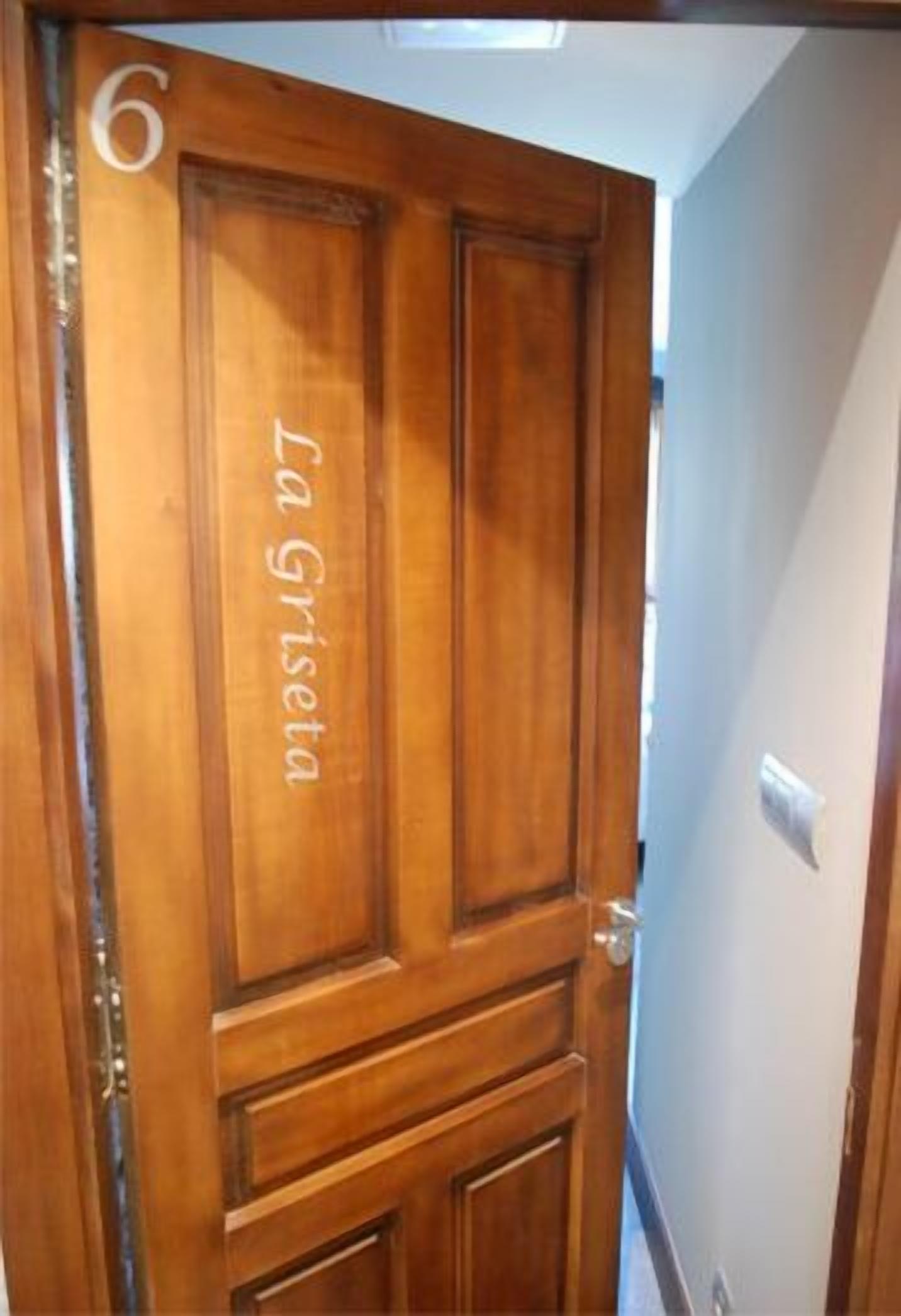 A wooden door with the number 6 and the name "La Griseta" on it.