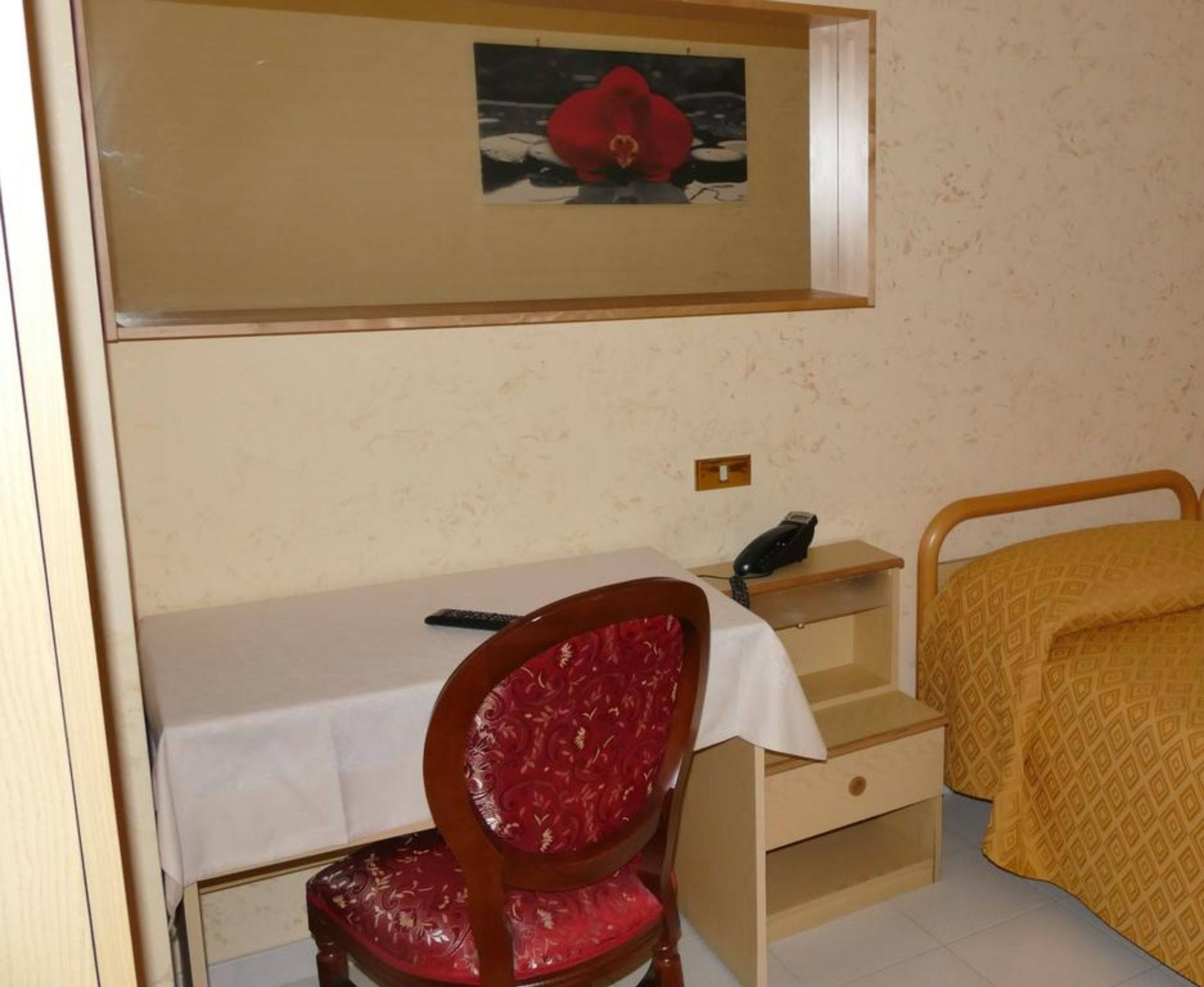 Ein Schlafzimmer mit einem Bett, einem Schreibtisch, einem Stuhl und einem Nachttisch.