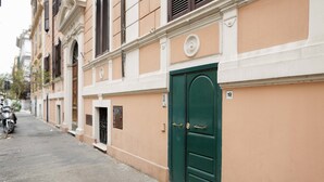 A street view of a building with a green door, numbered 19, and a small entrance door. - Caio Mario (Rome)