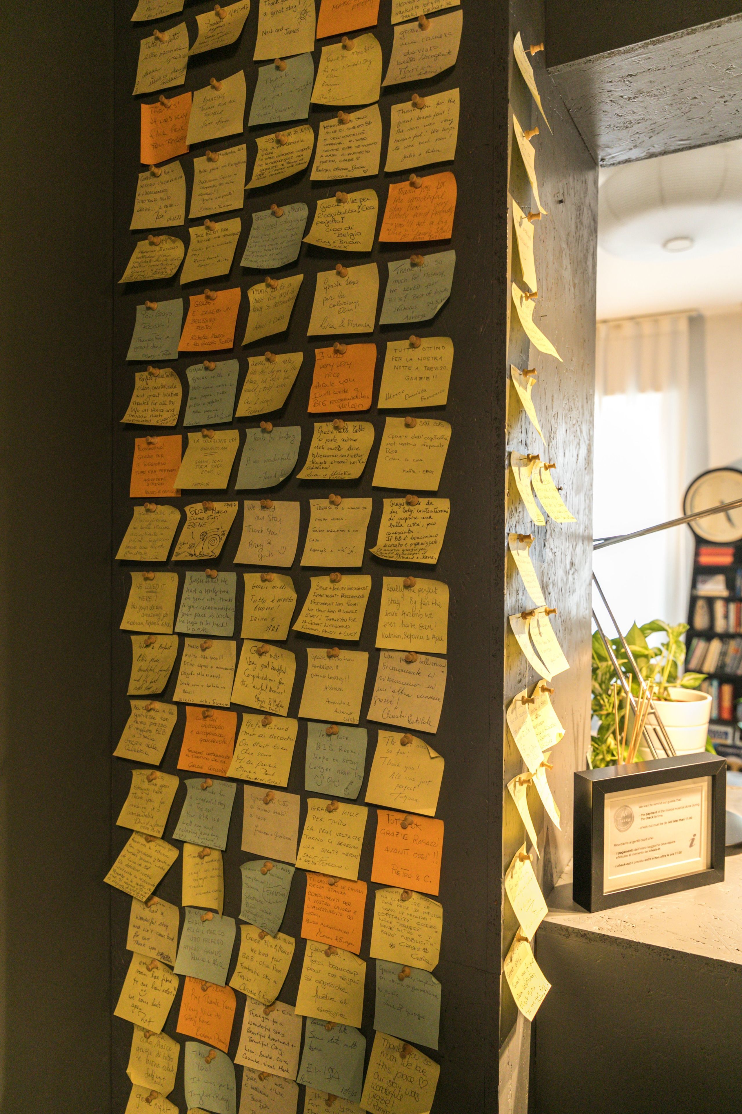 A wall covered with numerous sticky notes pinned to it.