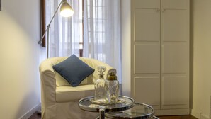 A room with a white sofa, a small round table with a glass top, and a lamp. - Gianicolo's Hill Suite Apartment (Rome)