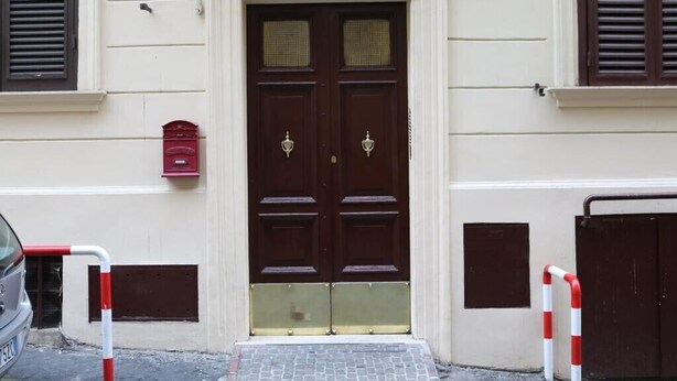 A double door with a brass handle, a red mailbox, and a gated entrance. - Gianicolo's Hill Suite Apartment (Rome)