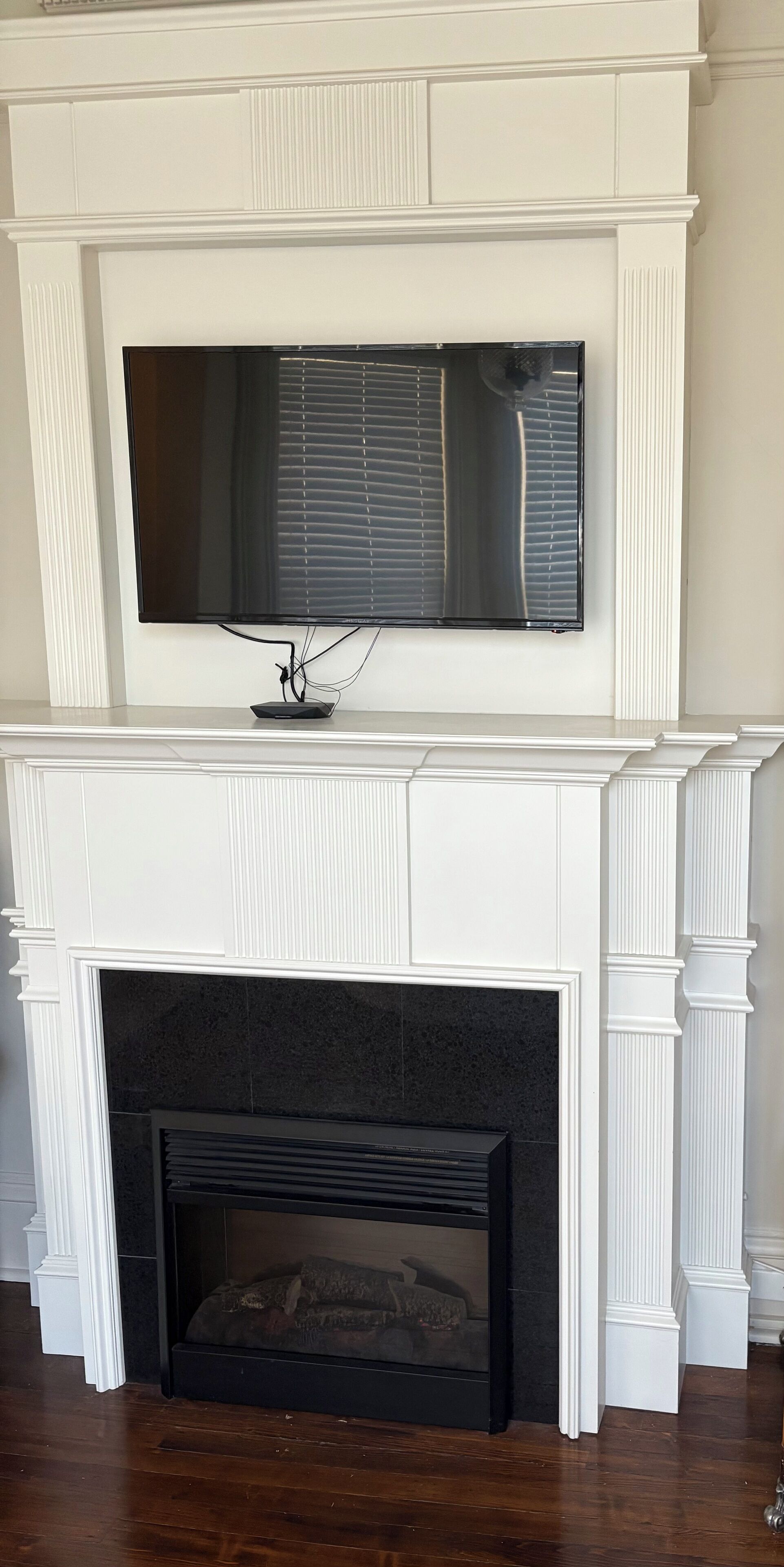 A fireplace with a flat-screen TV mounted above it.