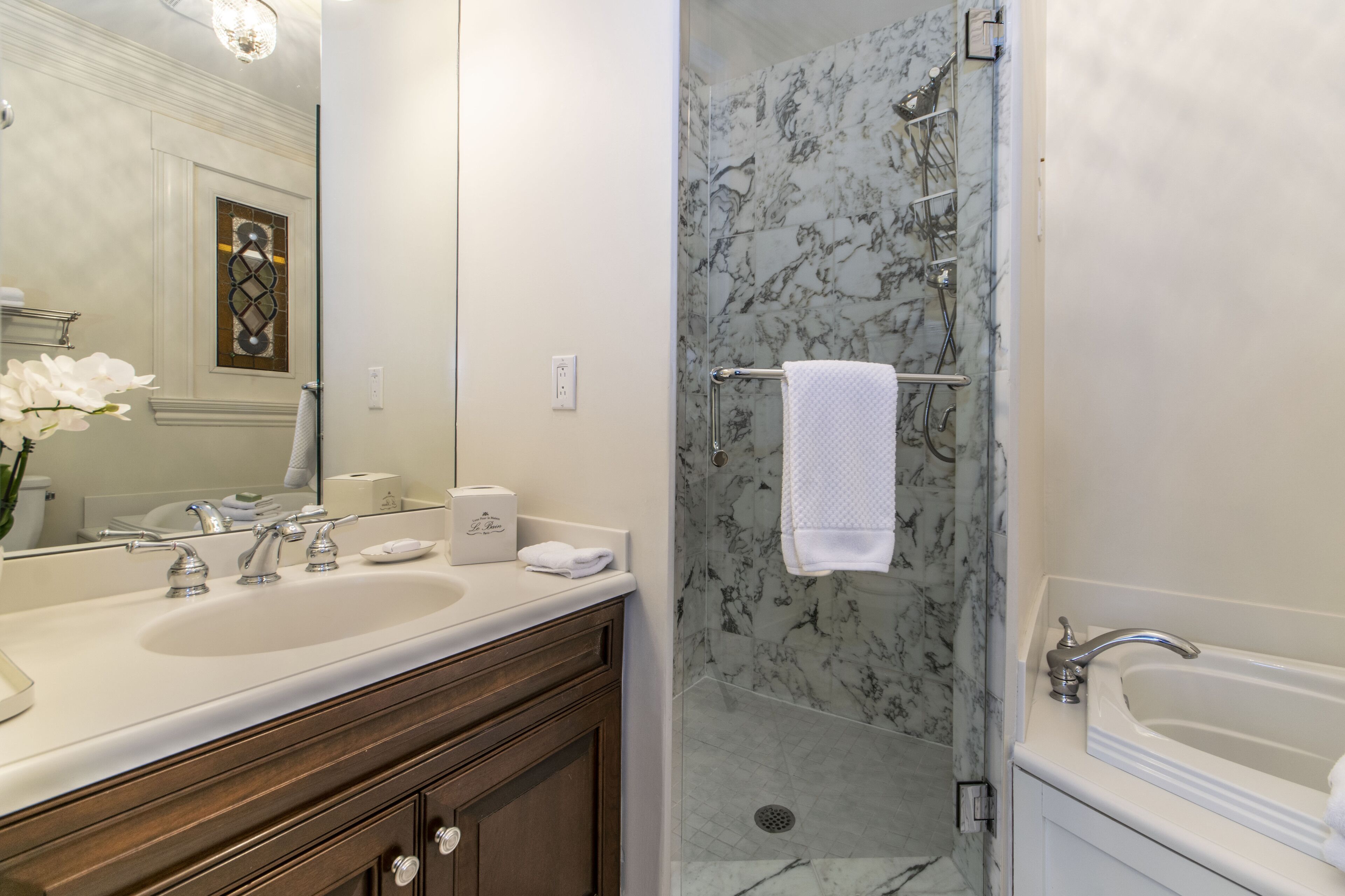 A bathroom with two sinks, a shower, and a bathtub.