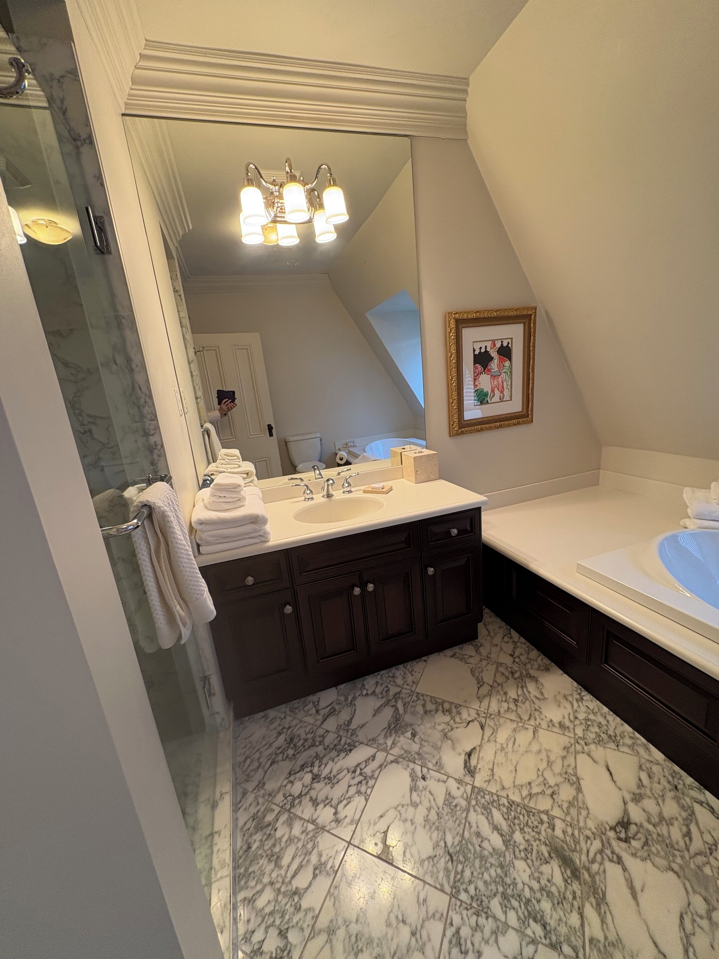 Een badkamer met een dubbele wastafel, een grote spiegel, een douche en een bad.