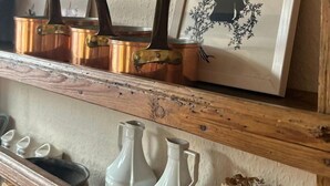 A shelf with copper pots, a framed silhouette, and white vases. - Hotel Finkenhof - Haus Meersmannufer (Hannover)