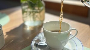 A cup of coffee being poured into a white cup on a saucer. - Hotel Finkenhof - Haus Meersmannufer (Hannover)