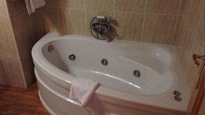 Een badkamer met een bad, een handdoekhouder en een toilet.