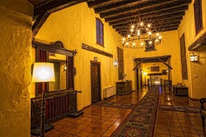 A corridor with a wooden ceiling, yellow walls, and a patterned carpet. - Bodega la Venta (Casas de los Pinos)