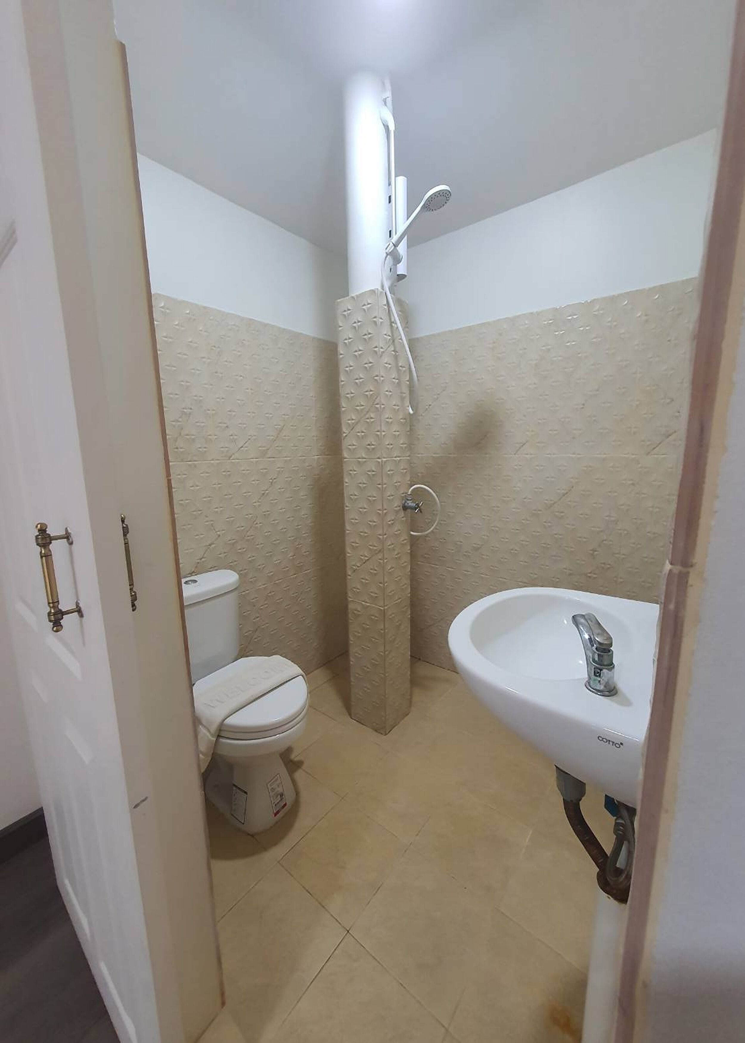 Une petite salle de bain avec des toilettes, une douche et un lavabo.