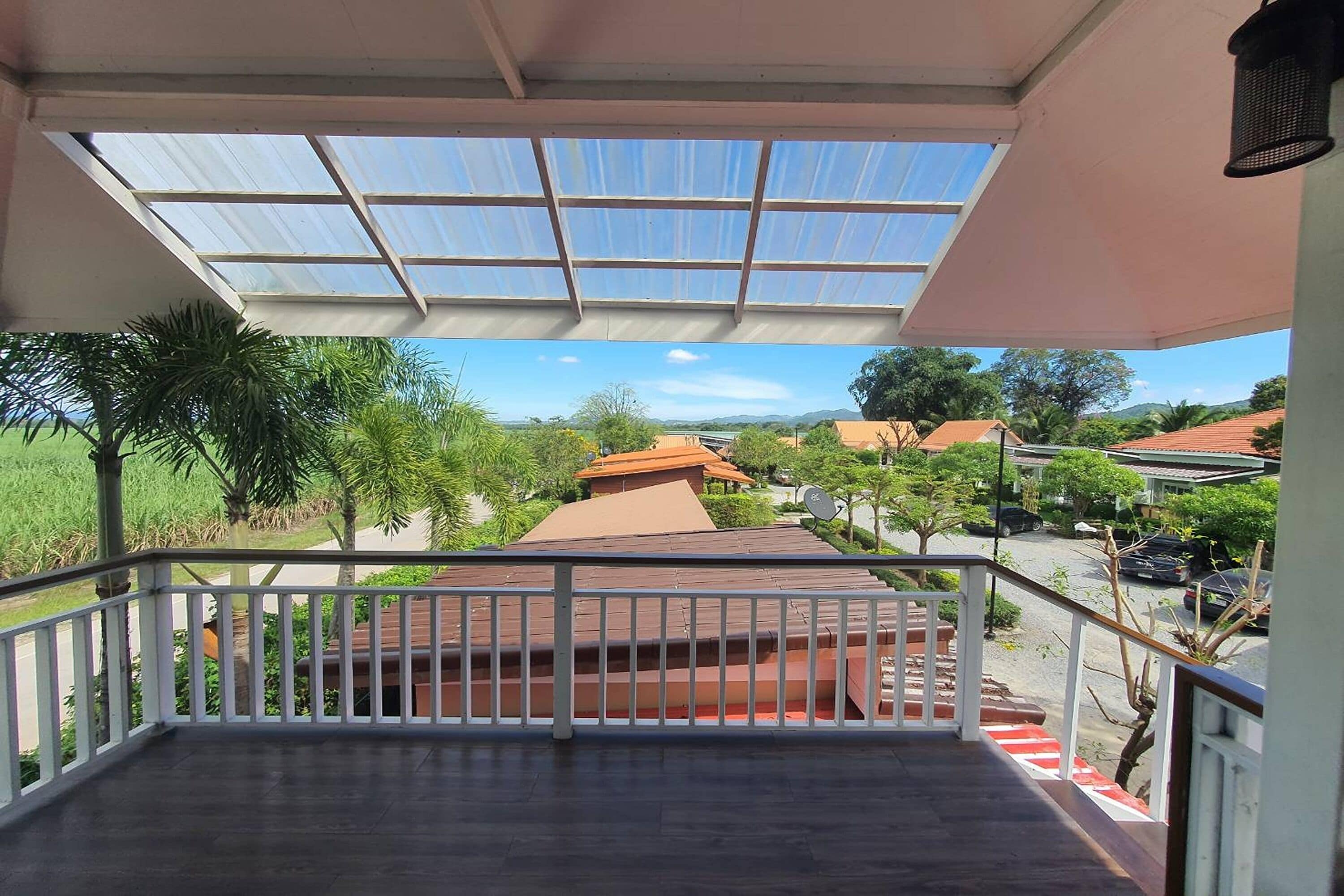 Een balkon met uitzicht op een woongebied, met huizen en groen.