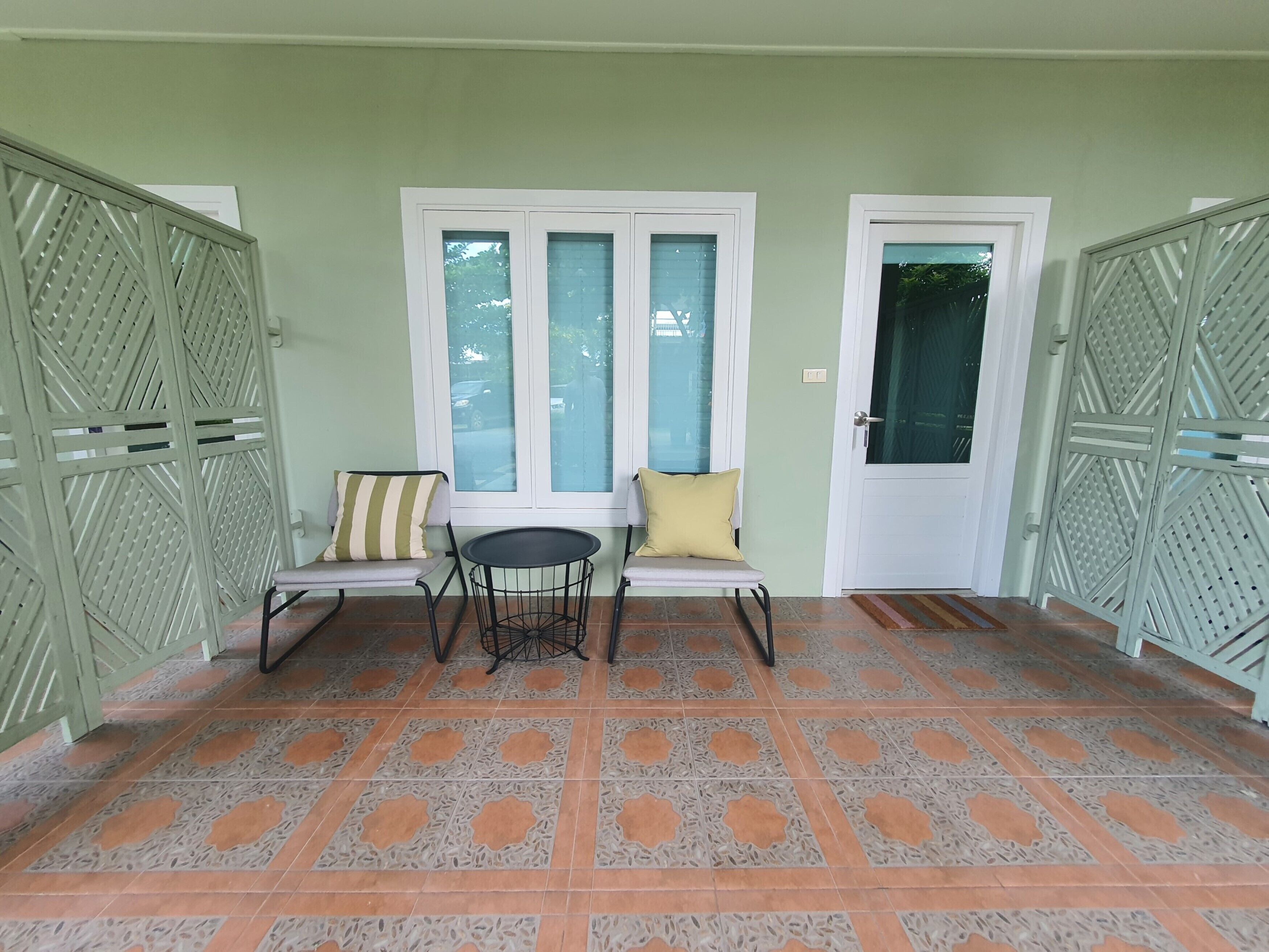 Une pièce comprenant un banc, une petite table et deux portes dotées de panneaux métalliques décoratifs.