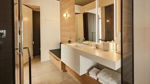 Un baño moderno con un espejo grande, dos lavamanos y un mueble de tocador de madera.