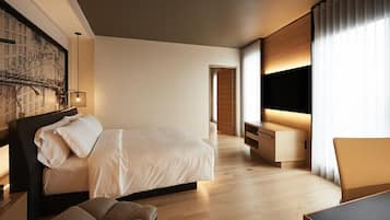 Una habitación de hotel moderna con una cama grande, un escritorio y un televisor.