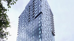 Un moderno edificio de gran altura con fachada de vidrio y entrada en esquina.