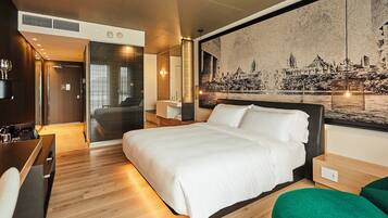 Une chambre d’hôtel moderne dotée d’un grand lit, d’un bureau et d’un coin salon.