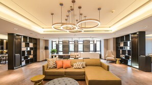 Una sala moderna con un sofá modular, un reposapiés y estanterías.