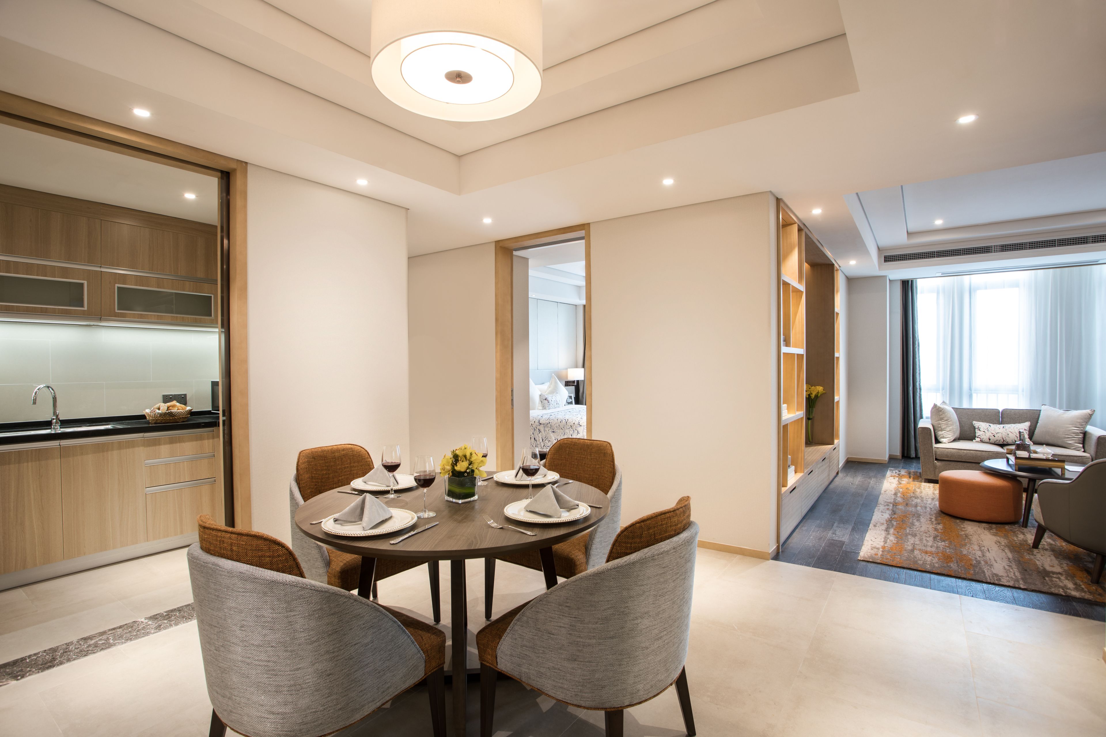 A modern living room with a dining area, a kitchen, and a sofa set.