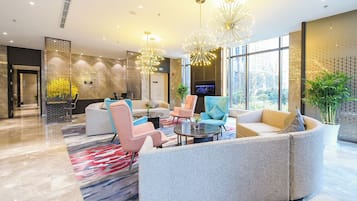 Un vestíbulo moderno con zona de estar, ventanas amplias e iluminación decorativa.