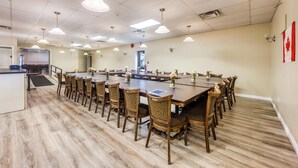 A conference room with a long table, chairs, and ceiling lights.
