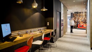 Een moderne werkruimte met een houten bureau, meerdere stoelen en hanglampen.