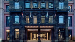 A grand building with a dark facade, large windows, and ornate balconies.