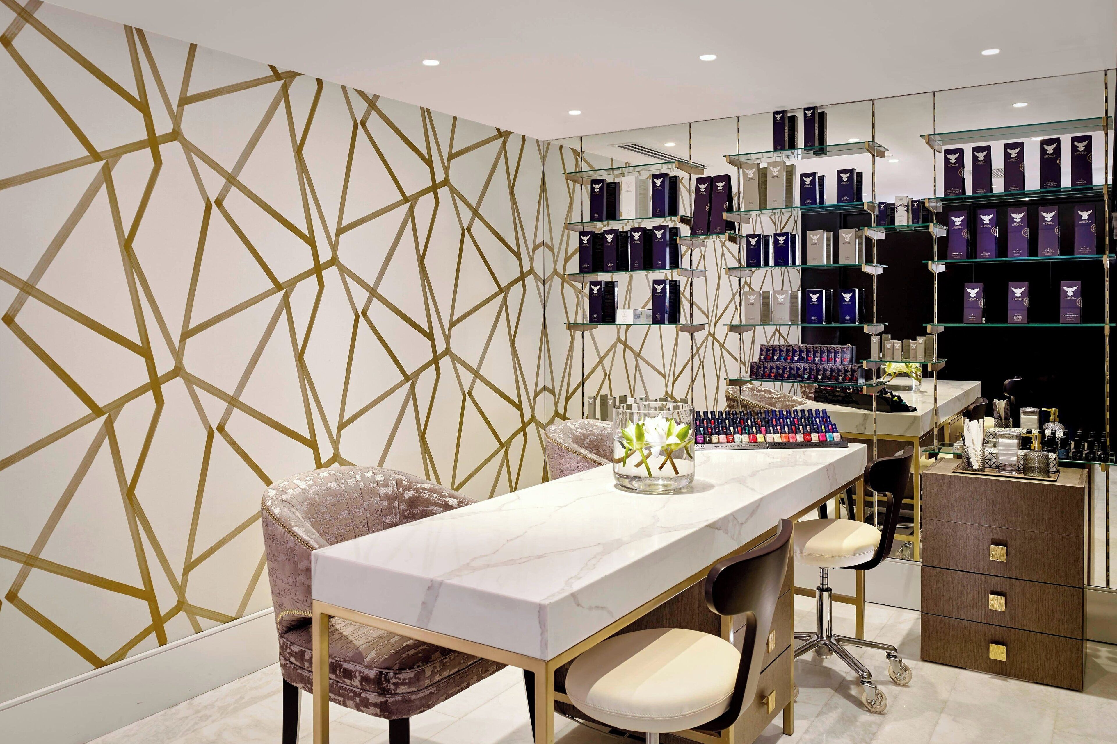 A modern bathroom with a geometric patterned wall, a marble countertop, and a vanity with a mirror.