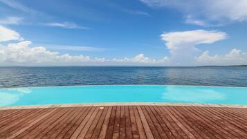 Una piscina al aire libre, sillones reclinables de piscina