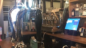 Un bar con una grifo etiquetado 'SHARP'S ATLANTIC' y una pantalla digital mostrando un menú.