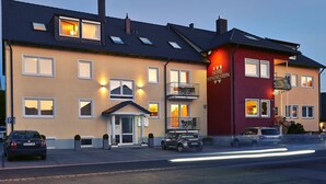 A hotel with a two-story structure, a balcony on the second floor, and a visible entrance with a door and windows. - Hotel Wendelstein (Wendelstein)
