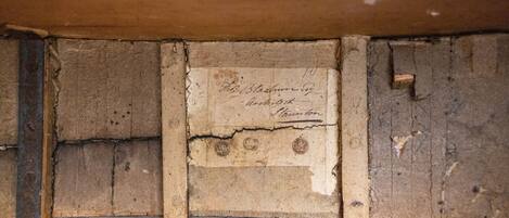 A close-up of a wooden wall with a worn, aged sign that reads "The Blacksmith's Inn" and "Arch Street, London."