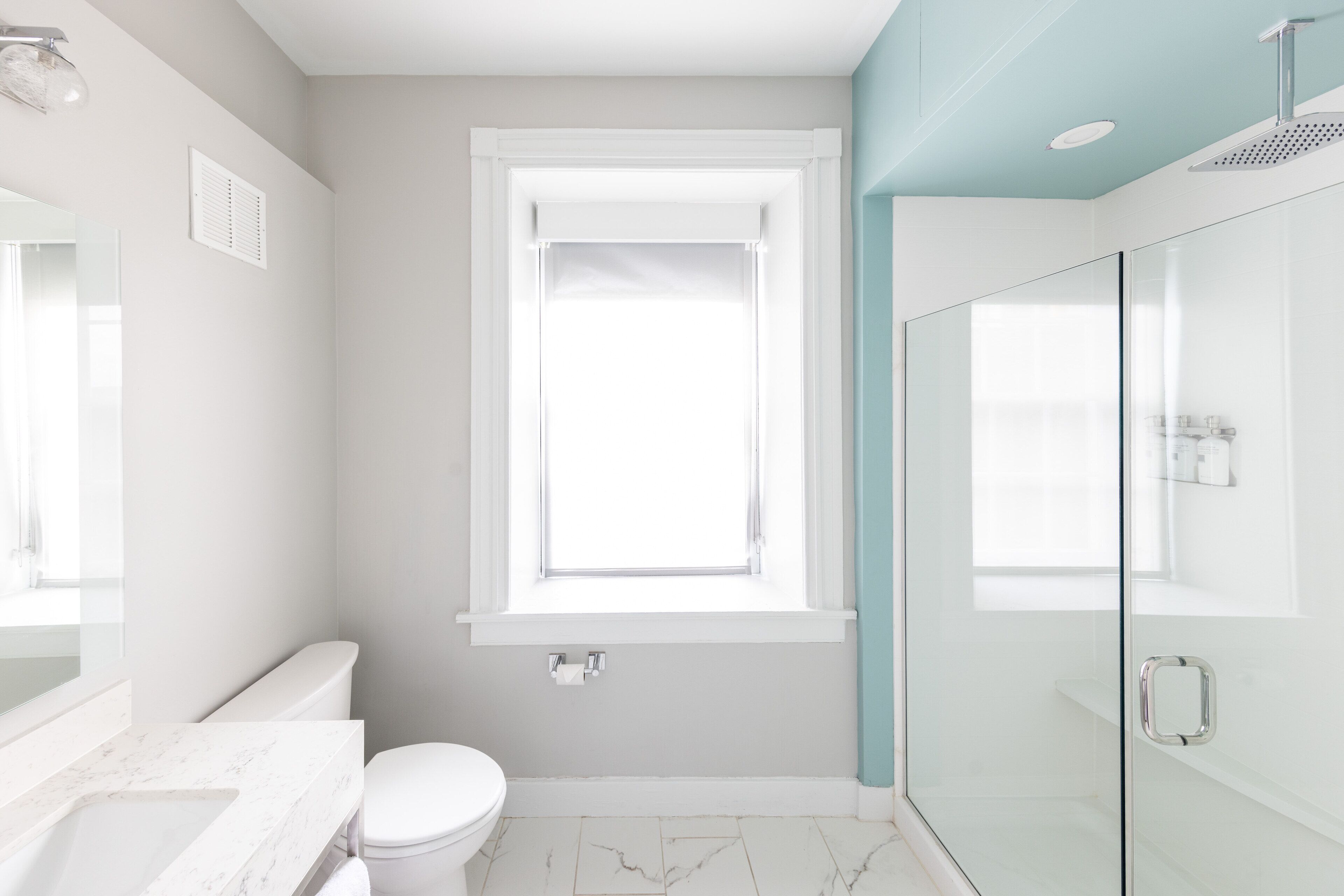 A modern bathroom with a toilet, sink, and shower area.