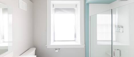 A modern bathroom with a toilet, sink, and shower area.
