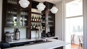 A modern kitchen with dark wood cabinets, a stainless steel island, and a wine rack. - The Blackburn Inn and Conference Center (Staunton)