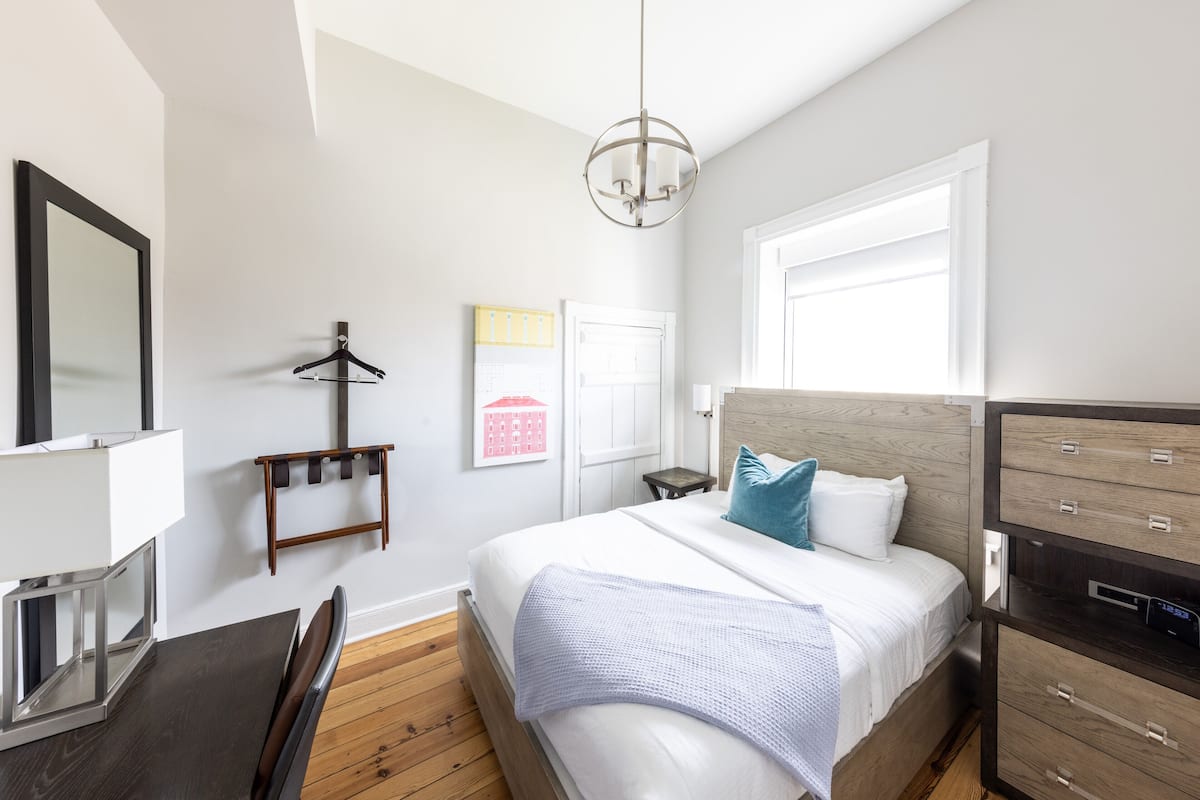 Une chambre d’hôtel moderne, dotée d’un grand lit, d’un bureau et d’une armoire.