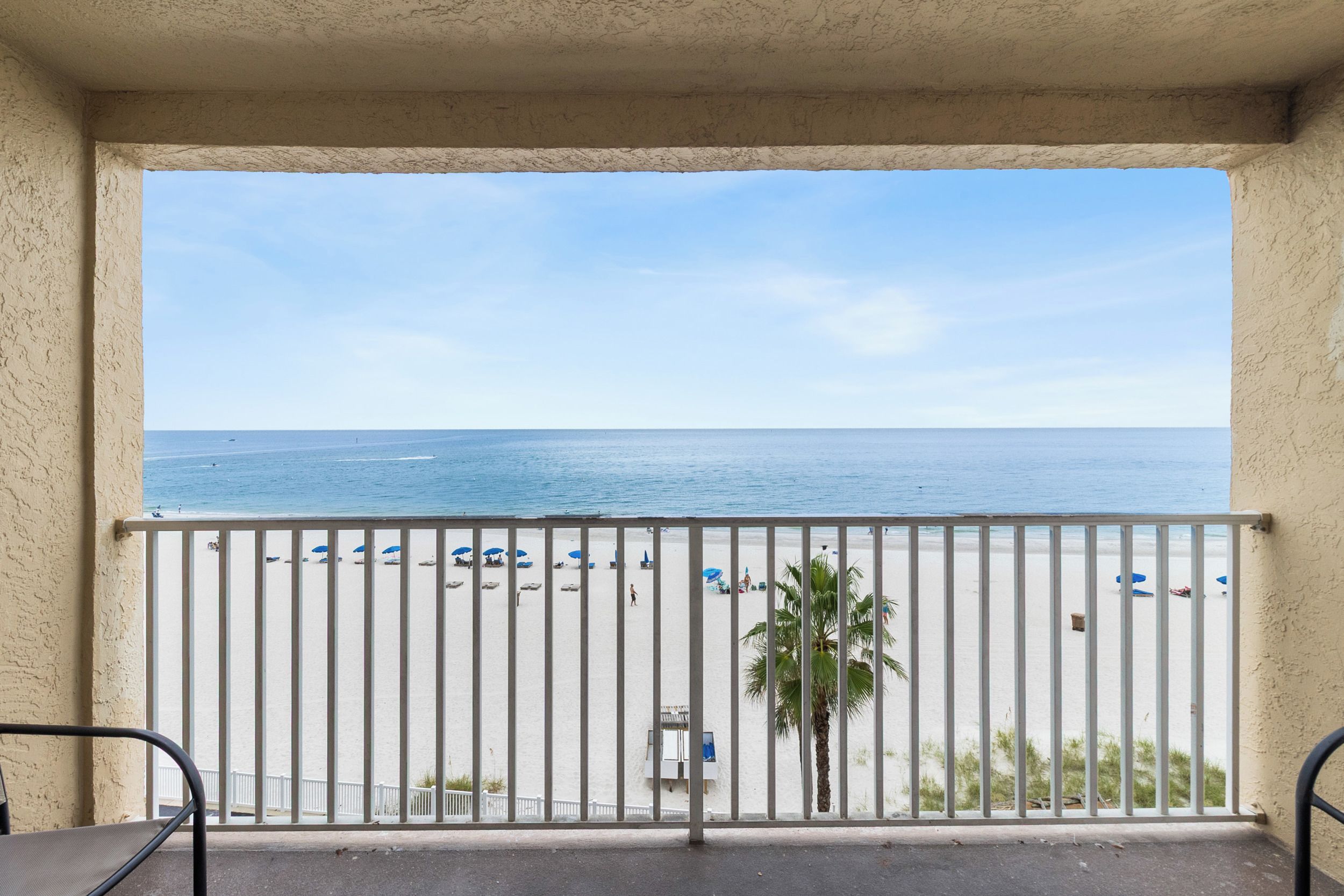Ein Balkon mit Blick auf Strand und Meer.
