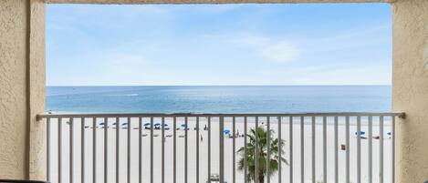 Ein Balkon mit Blick auf Strand und Meer.