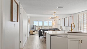Una cocina moderna con armarios blancos, una isla central y un lavavajillas integrado.